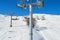 View from a moving ski chair lift in Winter, high above the ground, in Les Sybelles ski domain, France, on a day with perfect sky