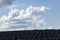 View of multiple solar panels against the sunny cloudy sky