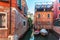 View of narrow Canal with boats and gondolas in Venice, Italy