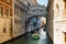 View of narrow canal with motor boat and gondolas in Venice