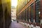 View of narrow street in Amsterdam with sunlight, brown and burgundy houses. Side view