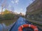 View from narrowboat traveling on a British canal in urban setting