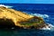 View of a natural cascade on the coast of the ocean under the blue sky