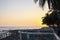 View of natural rocky beach and cliff with palm trees in El Tunco, El Salvador. Stones and rocks on the beach at sunset or sunrise