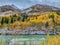 A View of the Nenana River Surrounded by Golden-Leaved Birch Trees in the Foreground of a Railroad Bridge and Mountainous Peaks