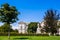 view of the Neue Burg Palace from the side of the Burggarten park. landscape of the park with neatly trimmed bushes, green lawn