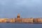 View of the Neva river embankment in St. Petersburg at sunset, buildings, dome of St. Isaac`s Cathedral, birds in the sky