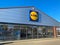 View on new moden lidl discounter store entrance against clear blue sky