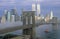 View of New York skyline, Brooklyn Bridge over the East River and tugboat in fog, NY