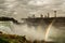 View of Niagara Falls. Raging stream of water flowing into the river, rainbows in the sun from the water. USA.