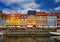 View of Nyhavn pier with color buildings, ships, yachts and other boats in the Old Town of Copenhagen, Denmark. Blue sky is in the