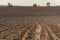 View oÐ° a ploughed fields with a tractor tire track.