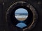 View on the ocean from a pipe or round shape hole with reflection inside the pipe. Abstract nature concept. Blue cool tone.