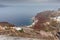 View of Oia Ammoudi bay with awesome red cliffs on a rainy day