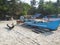 A view of an old battered blue wooden fishing boat standing on a sandy beach