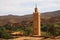 View on old berber arabian village with clay brick houses in valley with greenery and minaret