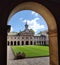 a view of an old building through a archway of a courtyard