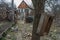 View of the old collapsing house in an abandoned village, a path and gate in the fence leads to the old street