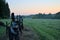 View of the old fence, green meadow and forest at sunrise.