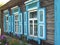 View of an old house with Windo with blue shutters in a Russian village.