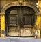 View of an old massive carved wooden door with an sculptured arch and yellow facade, Zagreb in Croatia