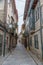 View at a old and narrow street with classic buildings on downtown Guimaraes city, man walking and store buildings