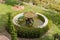 View of an old oval fountain surrounded by boxwood in the garden