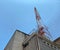 View of an old red and white telecommunication tower looking up from ground level