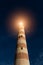 View of the old striped lighthouse beacon that shines brightly in the night. The main purpose of lighthouse is to serve