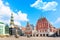 View of the Old Town Ratslaukums square, Roland Statue, The Blackheads House near St Peters Cathedral against blue sky in Riga,