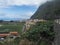 View of old village Agulo with colorful traditional houses, terraced fields, green field and mountain in green valley at