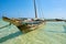 View of an old wooden boat or catamaran, anchored off the Kenyan coast in Africa in the clear sea