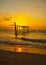 The view of the old wooden bridge decayed in the middle of the ocean in the evening.