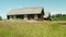 View of old wooden rural house near green lawn. Abandoned village