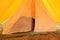 View in old yellow canvas camping tent with iron pegs