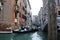 View of one of the many canals in Venice. Tourists sail on gondolas along the canal.