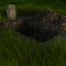 View of one open grave in a field with grass and a stone tablet