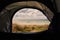 View from open door of a tent on a lovely sand dune with tall grass and beautiful ocean.