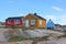 View of Oqaatsut, Greenland, with a group of brightly colored residential houses on a rocky terrain