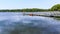 A view out onto the lake past the jetty toward the northern bank of Raventhorpe Water, Northamptonshire, UK