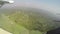 View out the window of prop plane flying over Uganda fields and farms