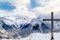 View from outskirts of Les deux Alpes village on mountain range and valley below with wooden cross