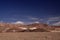 View over barren plain on brown hills contrasting with deep blue sky - Salar Salt flat near San Pedro de Atacama - Chile