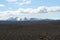 View over black wide endless black barren wasteland with snow capped mountains - Iceland