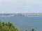 View over bushes at Moushole to the blue sea of the Cornish coast and Saint Michael\\\'s Mount Cornwall England