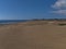 View over crowded beach Playa de Maspalomas with popular sand dunes and lighthouse in the south of island Gran Canaria, Spain.