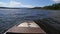 View over fishing metal boat nose against the wavy lake water