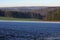 View over frost covered field to hilly forest