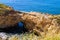 View over grass on natural sandstone bridge with arch in the ocean