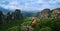 View over nunnery of Moni Agias Varvaras Roussanou and rocks of Meteora, Greece. UNESCO World Heritage. Cloudy sky, sun